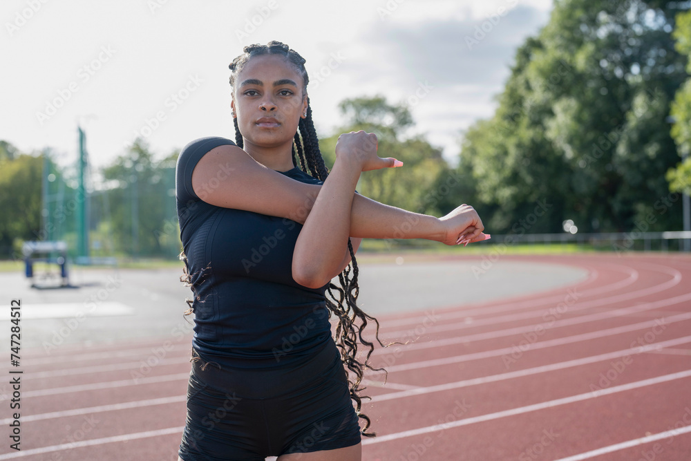 Female athlete stretching arms before training