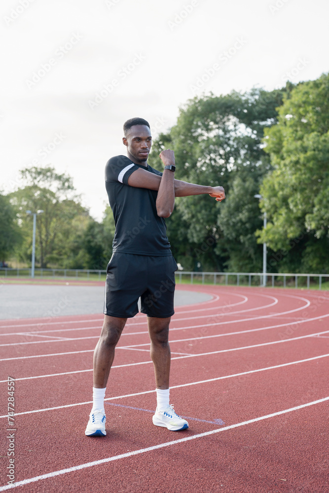 Athlete stretching before training at sports track Athlete stretching before training at sports track