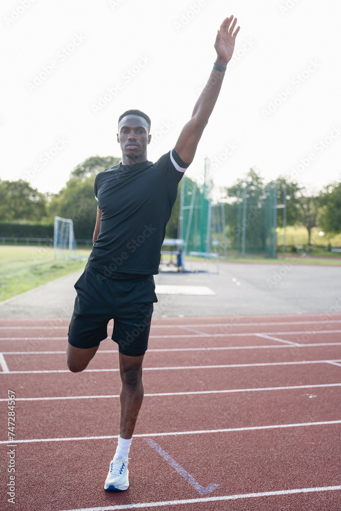 Athlete stretching leg before training at sports track