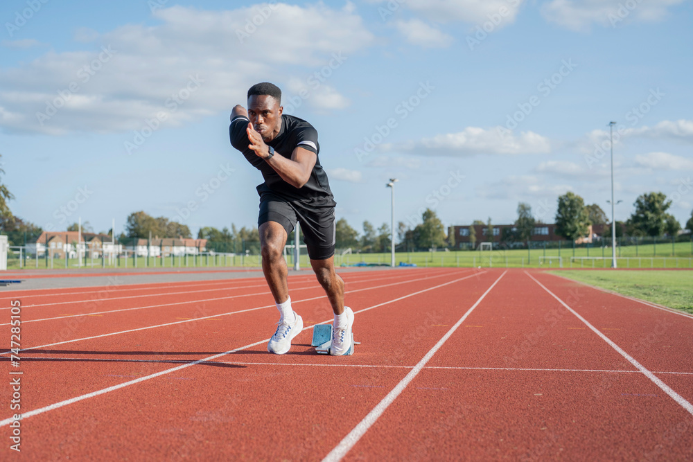 Athlete sprinting off at running track