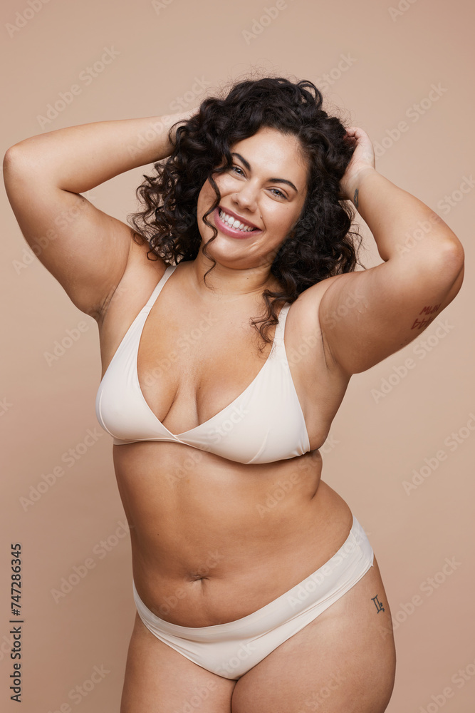 Studio portrait of smiling young woman wearing lingerie - obrazy, fototapety, plakaty 