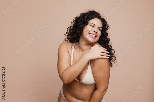 Studio shot of smiling young woman wearing lingerie