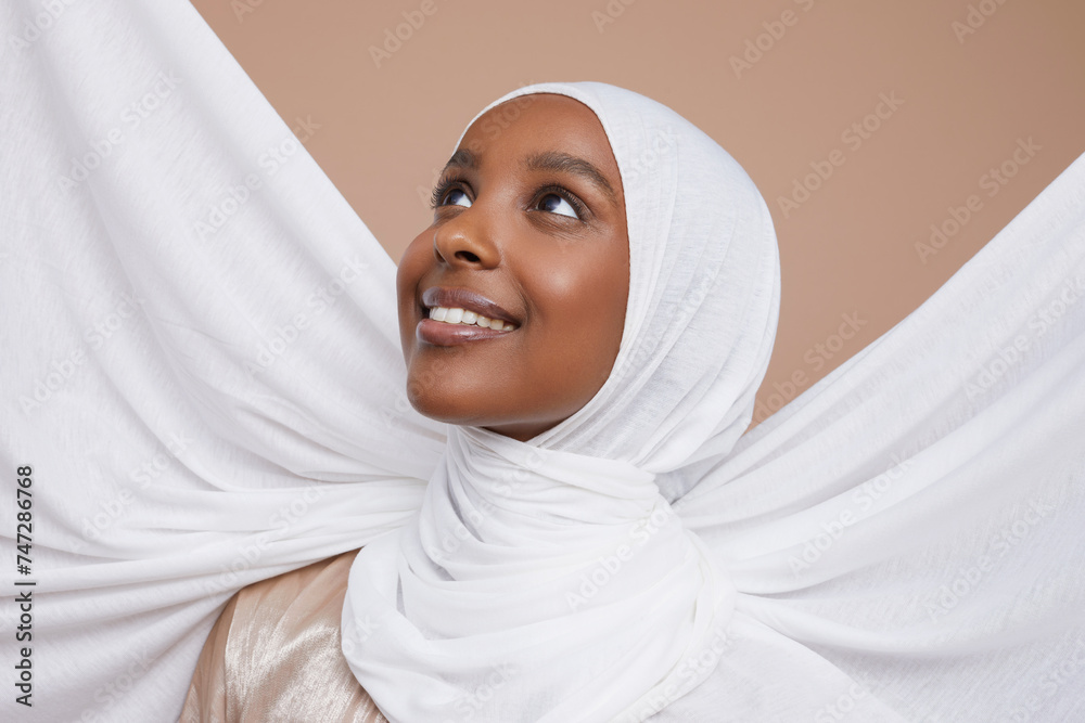 Studio shot of smiling young woman in white hijab Studio shot of smiling young woman in white hijab