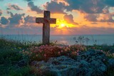 The sun sets creating a peaceful scene with a silhouette of a cross surrounded by wildflowers and rocks