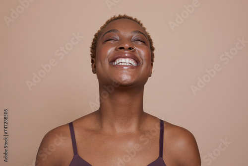 Studio portrait of smiling woman with eyes closed photo