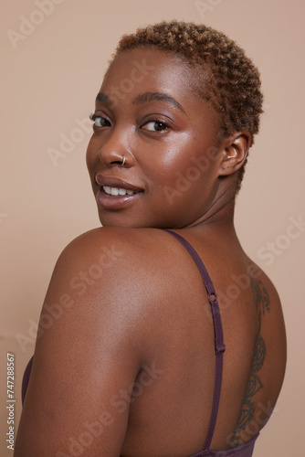 Studio portrait of smiling woman wearing bra