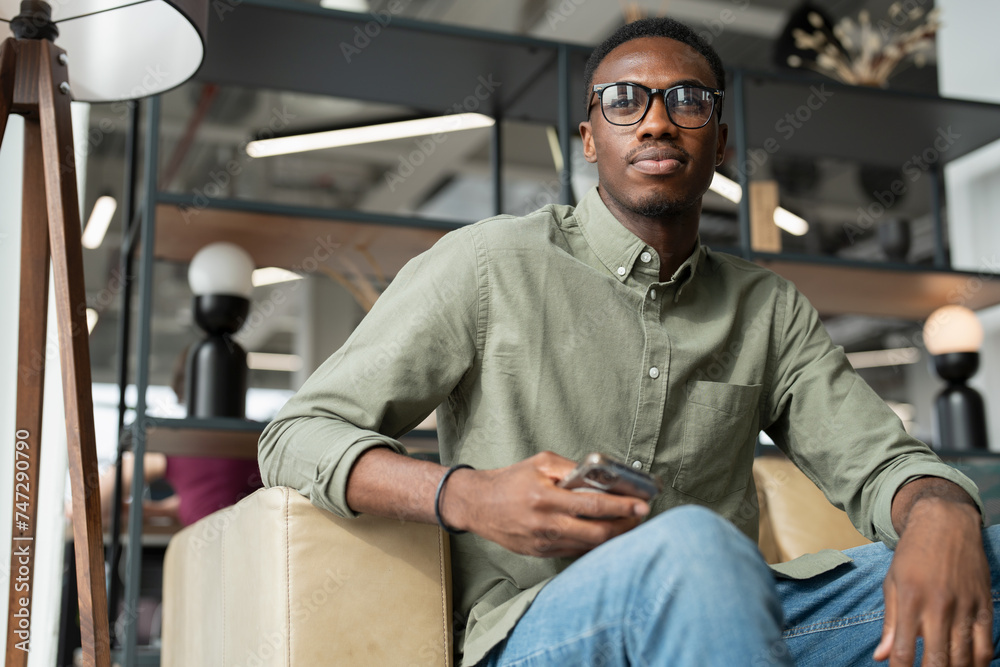 Fototapeta premium Young man sitting in office lounge