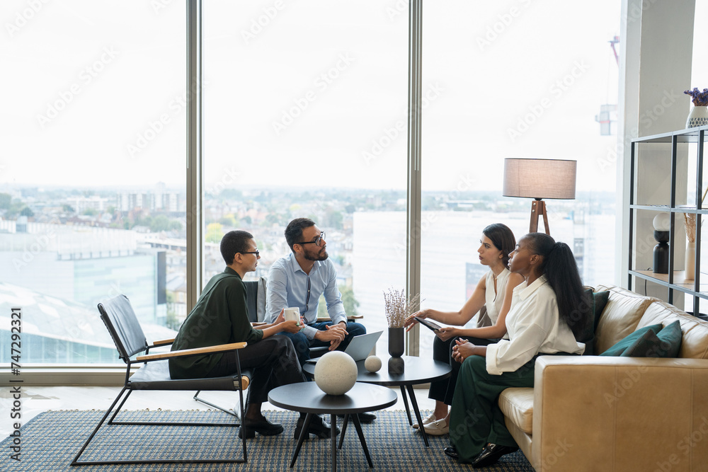Business people having meeting in office lobby Business people having meeting in office lobby