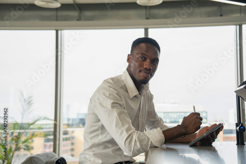 Portrait of young businessman using digital tablet in office