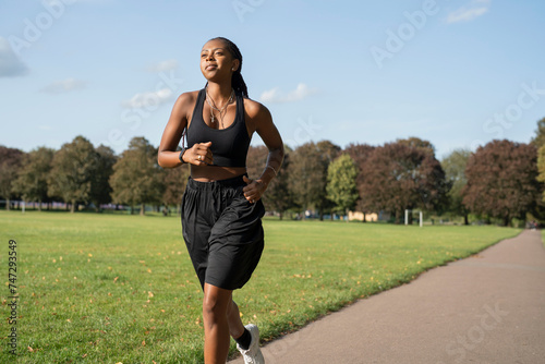 Young woman jogging in park photo