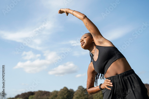 Young woman stretching in park photo