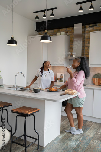 Lesbian couple chatting and eating in kitchen