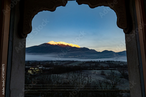 Castel di Ieri, Italy A landscape view over the Monte Sirente mountains and the Abruzzo National Park from an open window in a cottage at dusk. photo
