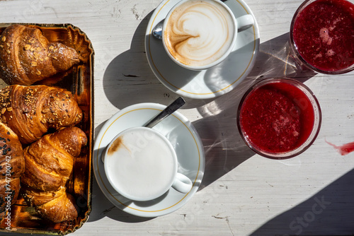 Raiano, Italy A tabletop display of fresh croissants, cappucinos and freshly squeezed blood-orange juice on a cafe table.