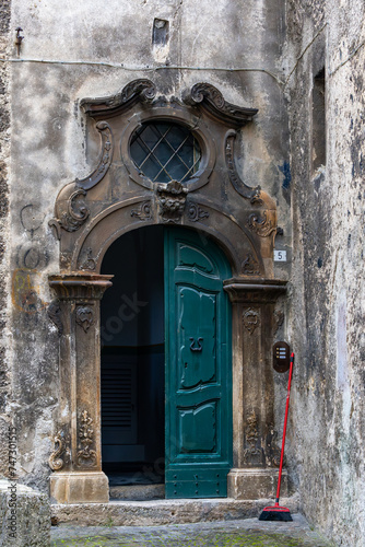 Scanno  ItalyA green door and a red broom in a narrow alley.