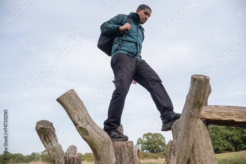 Man with backpack walking on old wooden posts