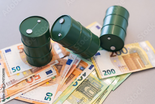 oil barrel with money, euro banknotes closeup photo