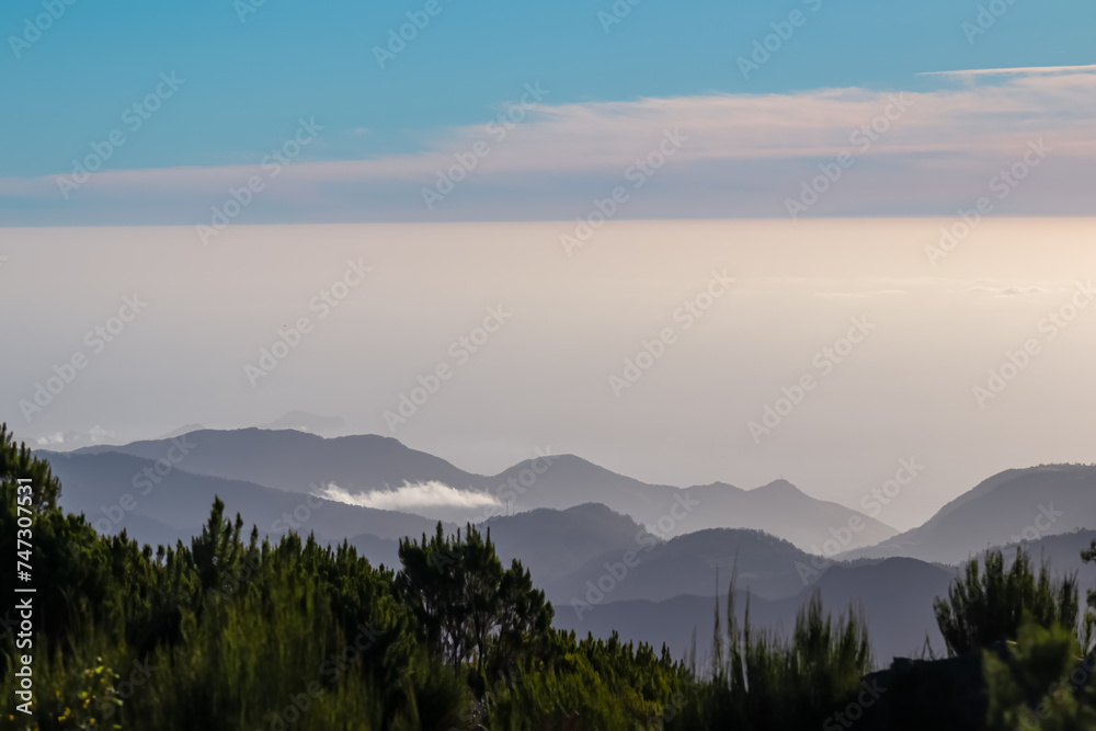 Scenic view of misty hills and coastline of majestic Atlantic Ocean on Madeira island, Portugal, Europe. Idyllic hiking trail to mountain peak Pico Ruivo. Coastal landscape on sunny day. Tranquility