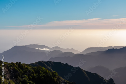 Scenic view of misty hills and coastline of majestic Atlantic Ocean on Madeira island, Portugal, Europe. Idyllic hiking trail to mountain peak Pico Ruivo. Coastal landscape on sunny day. Tranquility © Chris