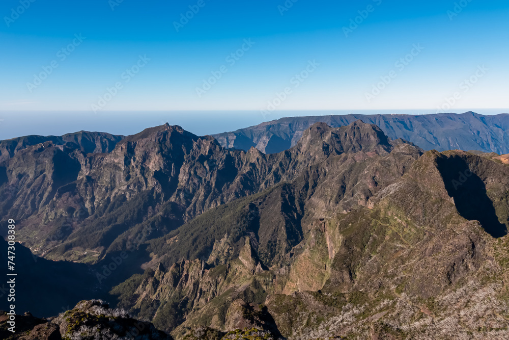 Scenic view of mountain ridges and majestic canyon of rugged terrain on Madeira island, Portugal, Europe. Idyllic hiking trail to mountain peak Pico Ruivo. Coastal landscape on sunny day. Tranquility