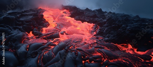 A riveting sight of molten lava from Big Island Hawaii streaming into the cool waters of the Pacific Ocean. The dynamic clash of elements creates a striking display of raw power and geologic processes