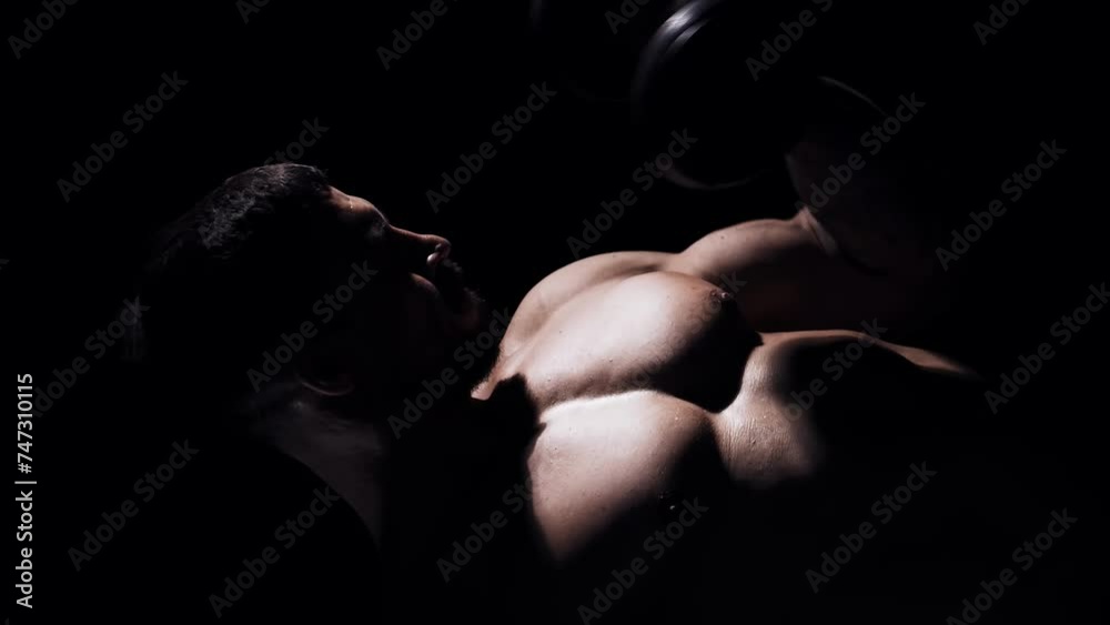 Fit and sporty bodybuilder over black background. Bodybuilder training using barbell. The concept of sport and fitness. Fit and sporty bodybuilder over black background. Bodybuilder training using barbell. The concept of sport and fitness.