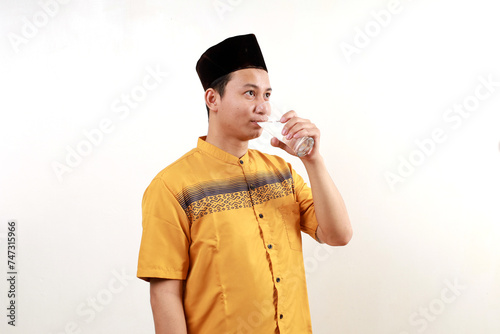 Young asian muslim man drinking for break fasting. Ramadan concept
