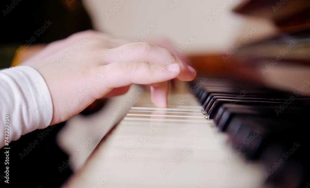 Experienced hand of the old music teacher helps the child student. Experienced master piano hand helps the student, close-up.