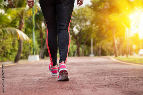Fototapeta Naklejka Na Ścianę i Meble -  Woman running, training and jogging in summer park, close up on running shoes