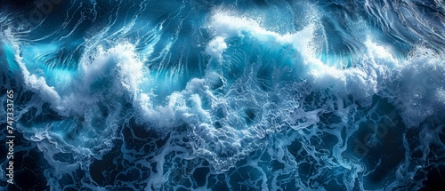 An aerial view of turquoise ocean water with splashes and foam as an abstract natural background