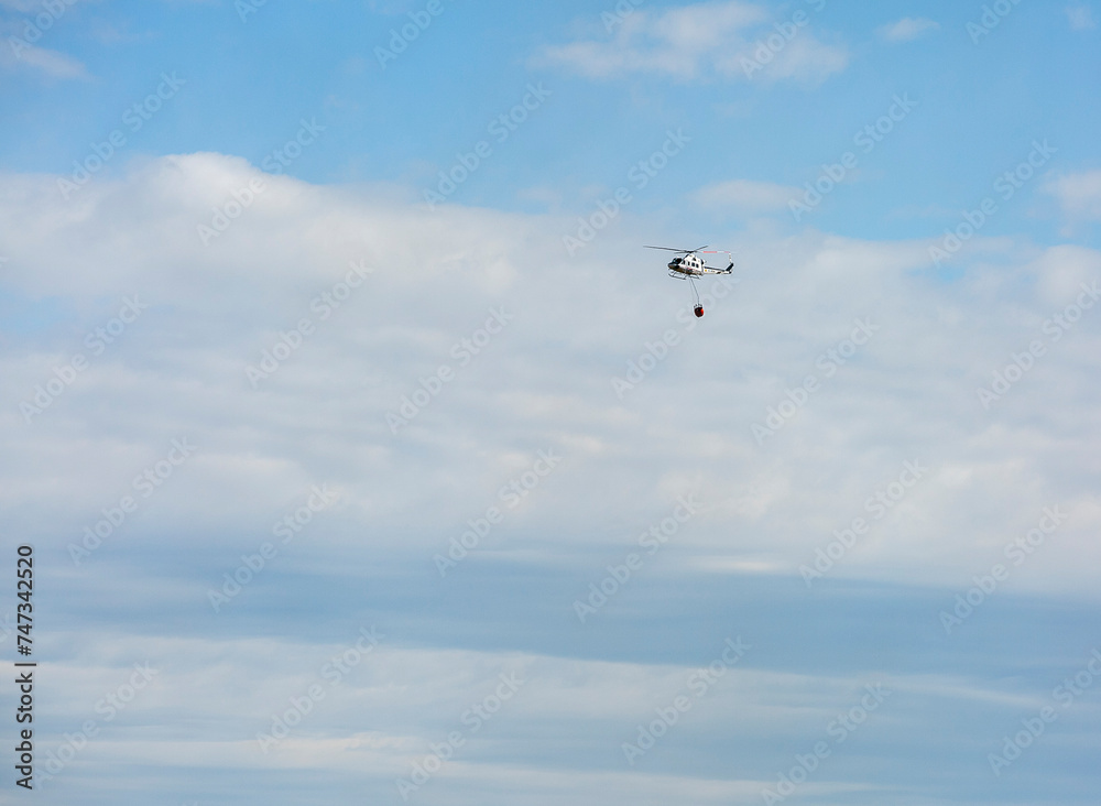 Fototapeta premium firefighting helicopter hydrating a fire