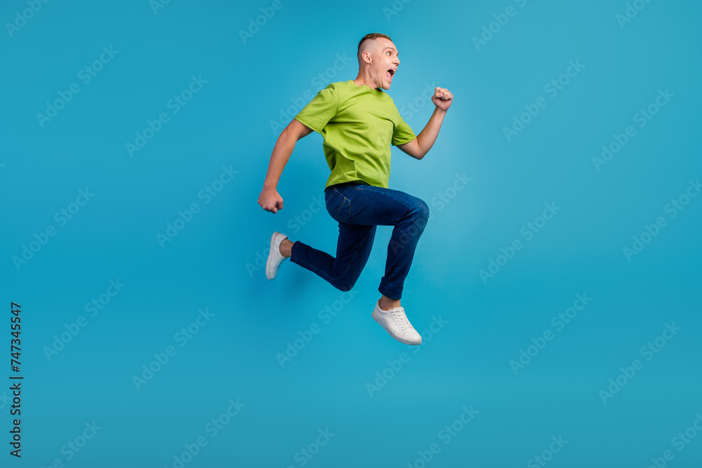 Full length profile photo of cheerful man run empty space isolated blue color background