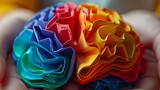 Colorful origami paper rolls in brain form at hands. Autism, memory loss, dementia, epilepsy and alzheimer awareness, world mental health day, Parkinson day concept.