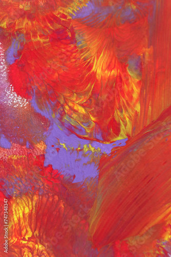 Abstract background of acrylic paint in purple, red and yellow tones.