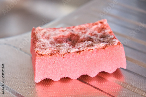 The view of a worn kitchen sponge for washing dishes. Selective focus. Side view