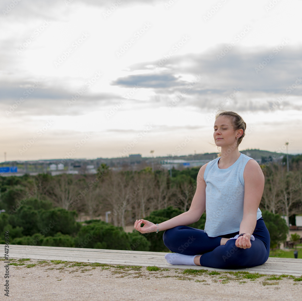 Young fit woman practice meditation outdoors
