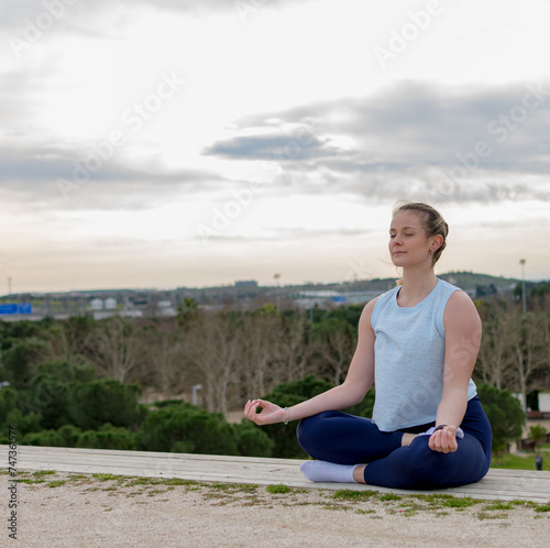 Young fit woman practice meditation outdoors