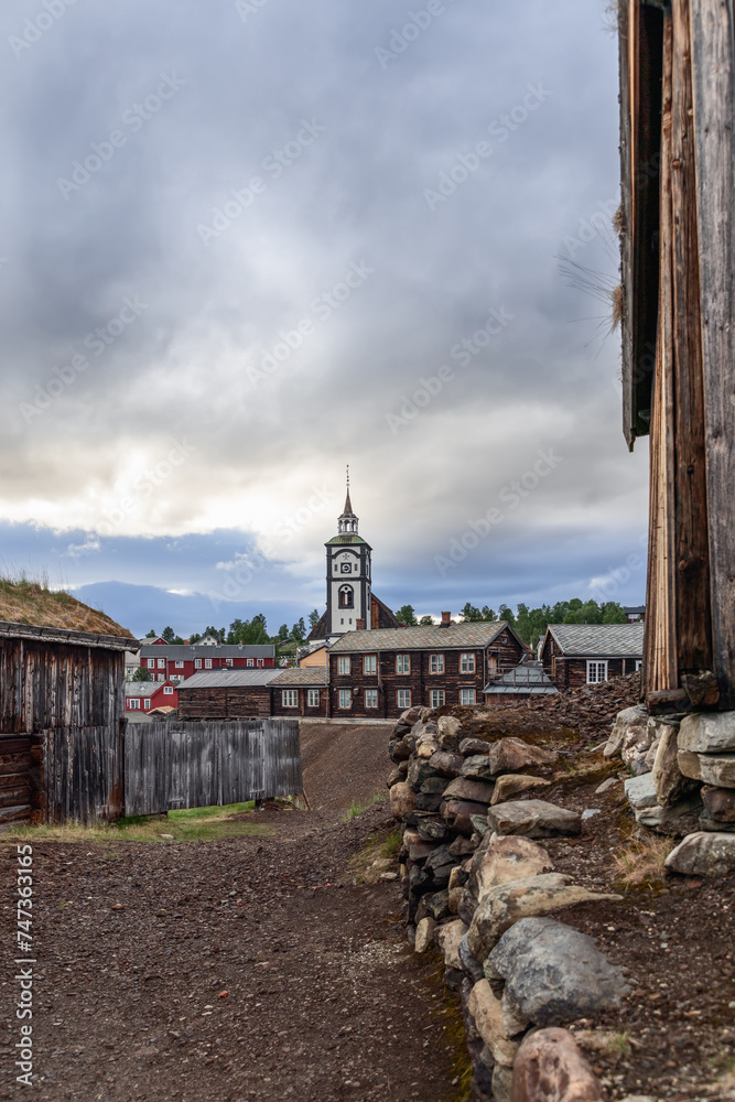 In this vertical perspective, Roros church stands tall among the historic timber buildings, captured from a path. Norvay
