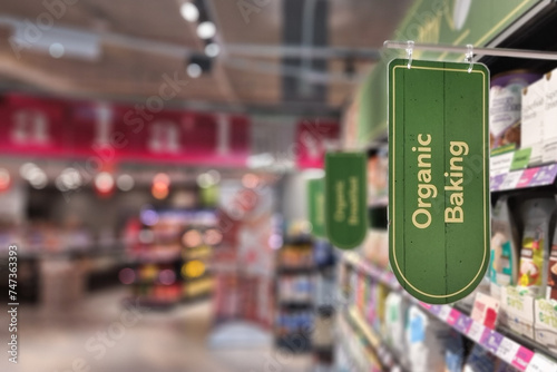Organic Baking signage or word at the aisle of supermarket with defocused merchandise on shelf