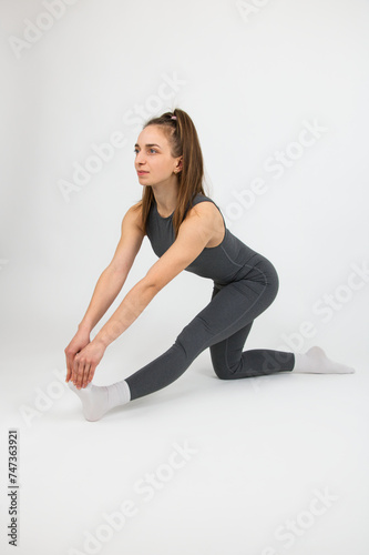 Girl athlete doing yoga demonstrating exercises on white background
