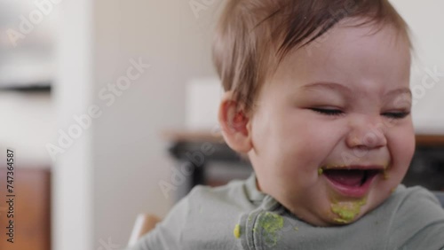 Smiling baby boy covered in avocado