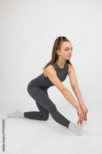 Girl athlete doing yoga demonstrating exercises on white background