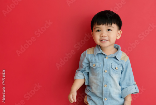 Smiling Asian baby toddler isolated on red background with copy space