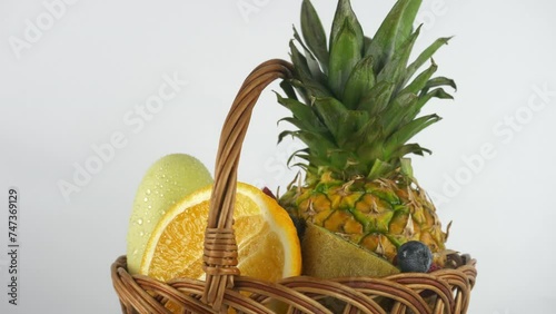 Ripe juicy pineapple and orange and grapefruit slices in a basket
