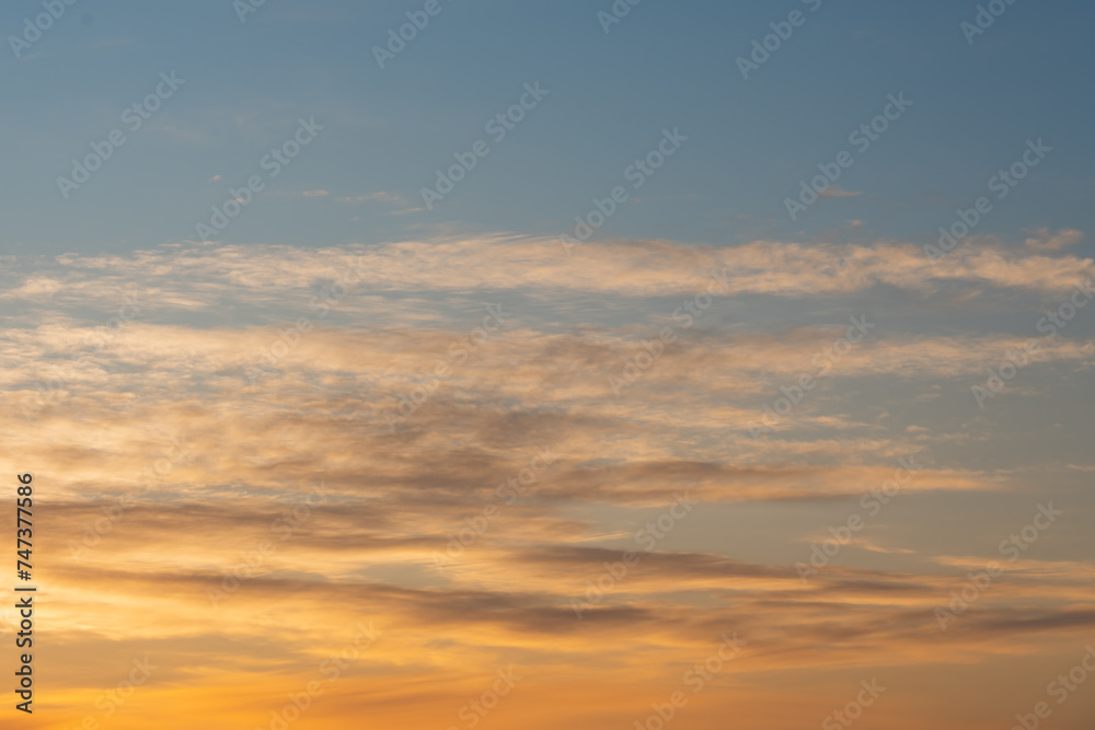 Photo background texture of orange sky at sunset with clouds.