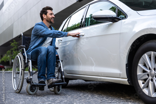Bearded disabled man in a wheelchair near the car