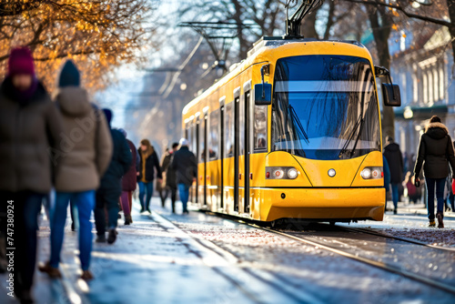 Yellow tram moves its track. Passengers on background. Concept of convenience and comfort from using green and eco-friendly public transport in bad, cold weather in an urban environment in winter