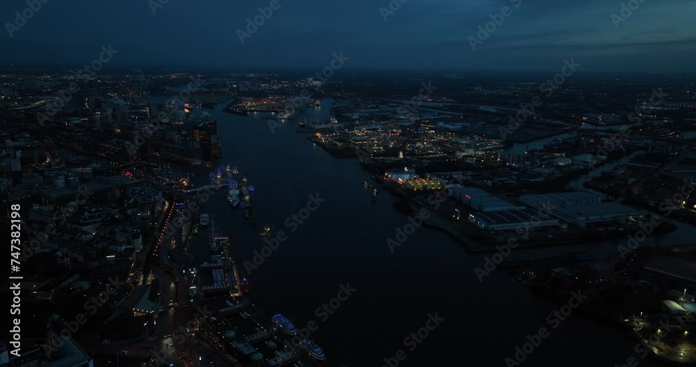 ELbe river in Hamburg and the city center along the river at night. On one side we see the Hamburg port and on the other the St Pauli city center. ELbe river in Hamburg and the city center along the river at night. On one side we see the Hamburg port and on the other the St Pauli city center.