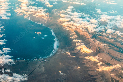 Caleta de Famara and the Bahia de Penedo on the Canary Island of Lanzarote, Spain viewed from a passing aircraft towards sunset.