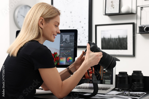 Professional photographer with digital camera at table in office
